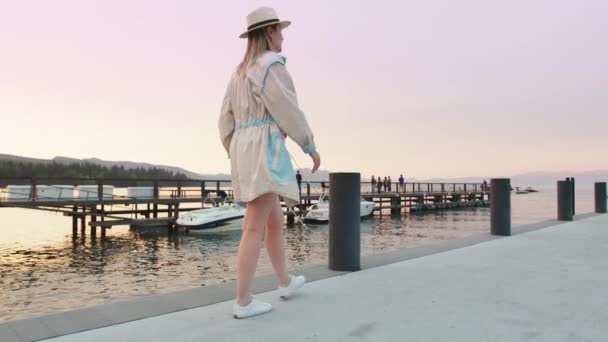 Cinematic slow motion kvinnlig resenär utforska sjön Tahoe vid natursköna rosa solnedgång — Stockvideo