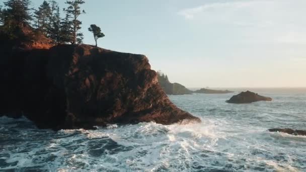 Letecký pohled na oceánské vlny se lámou na skalách při západu slunce, modré moře vlny 4K Oregon — Stock video
