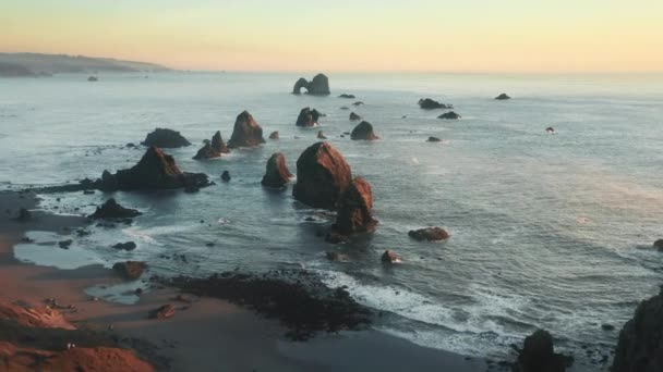 Scénický výhled na moře na skalnaté pláži s filmovými vrcholy mořských útesů při západu slunce — Stock video