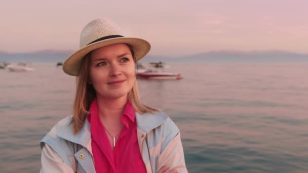 Lycklig ung kvinna njuter av livet på sjön Tahoe i rosa solnedgång, 4K slow motion — Stockvideo