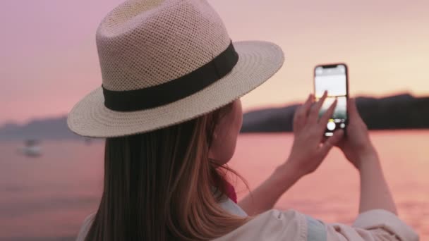 Vrouw reizen blogger bij mooi meer Tahoe, het maken van foto 's van roze zonsondergang 4K — Stockvideo