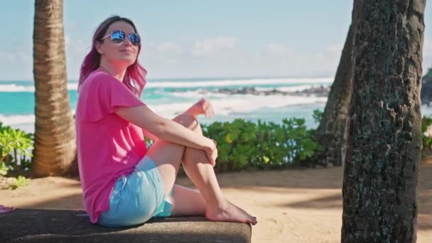 Mulher com cabelo rosa relaxante no parque de praia na ilha tropical, férias de verão — Vídeo de Stock