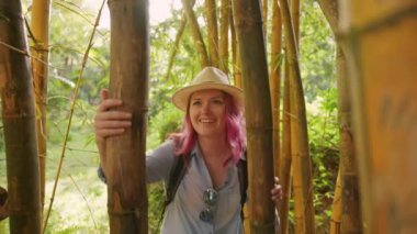 Pembe saçlı güzel bir kadın. Yoğun bambu ormanlarında yürüyor.
