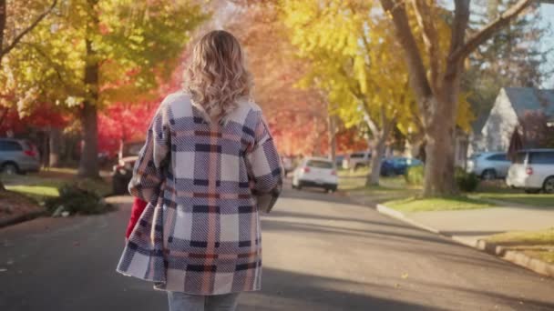 Güneşli bir sonbahar gününde küçük bir kasabanın önünden geçen arka plan kadını, 4K görüntüsü ABD — Stok video