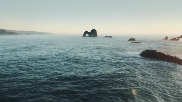 Drone volant rapidement à haute mer cinématographique rocher avec arc naturel coucher de soleil, Oregon 4K — Video