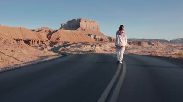 Kvinna i casual sweatshirt och joggare promenader på väg med berg landskap — Stockvideo