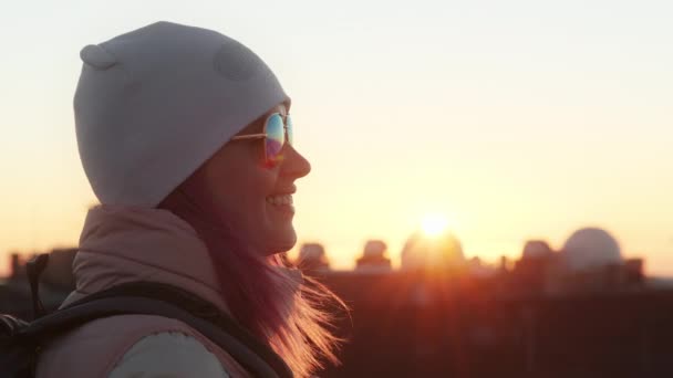Glücklich lächelnde Frau sieht goldenen Sonnenuntergang über Observatorium auf Berggipfel. — Stockvideo