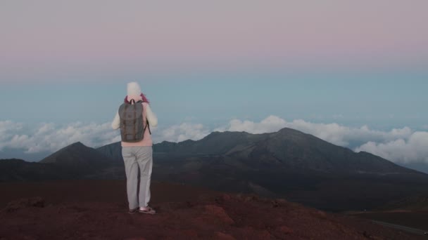 Viajero de cámara lenta 4K celebrando escalada en la cima de la montaña y levantando brazos — Vídeos de Stock