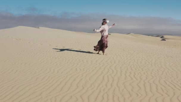 Girl uses virtual augmented reality glasses in magic atmosphere of summer desert — Stock Video