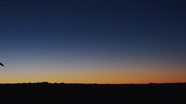 Filmischer Blick auf die Silhouette des Reisenden beim Wandern am hohen Berg bei goldenem Sonnenuntergang — Stockvideo