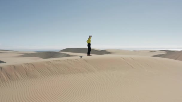 Mujer futurista luchando y disparando en gafas AR al aire libre en dunas de arena 4K — Vídeo de stock