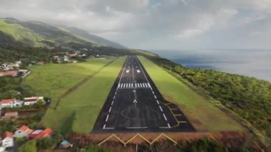 Airplane landing on runaway of airport in village at Sao Jorge island, Azores