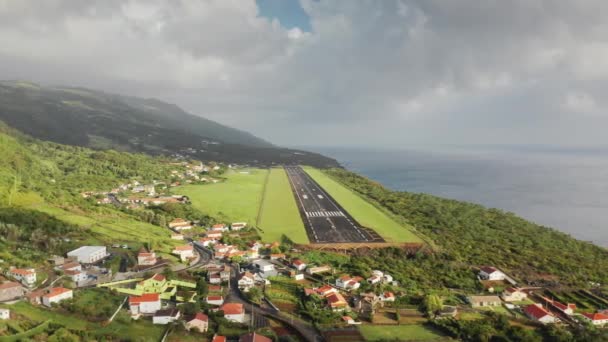Vesnice ležící na kopcích zelených hor na ostrově Sao Jorge, Azory — Stock video