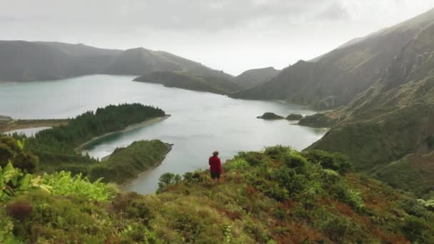 Mann klettert mit endemischen Pflanzen auf den Berg — Stockvideo