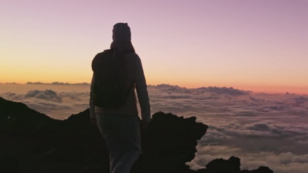 Sportliche Frau beim Bergsteigen, Erfolgspose bei rosa Sonnenuntergang über Wolken 4K — Stockvideo