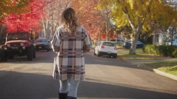 Automne doré au ralenti, jeune femme marchant dans la rue dans une petite ville de banlieue — Video