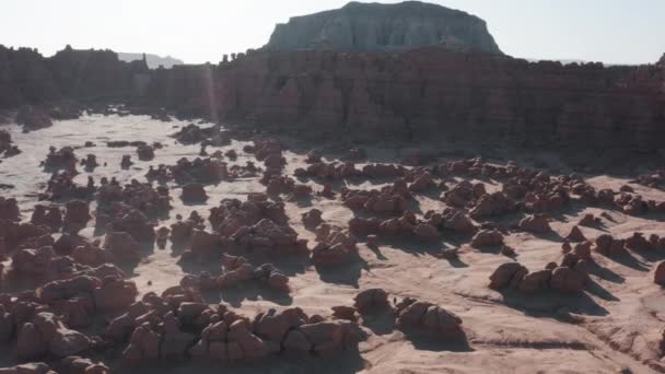 Drone volant au-dessus du voyageur explorant le désert rouge dans la vallée de Goblin, Utah 4K — Video