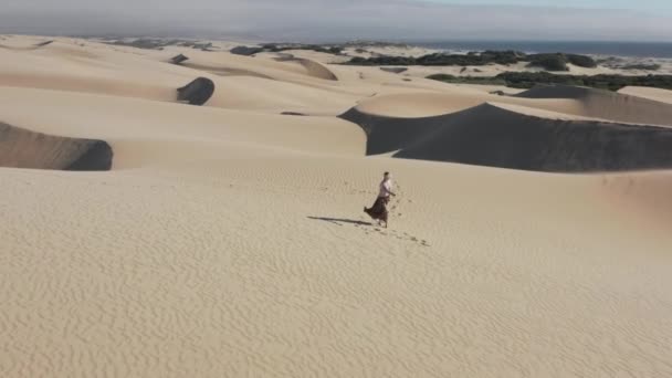 Artista femenina en auriculares de realidad aumentada creando pintura abstracta en las dunas — Vídeos de Stock