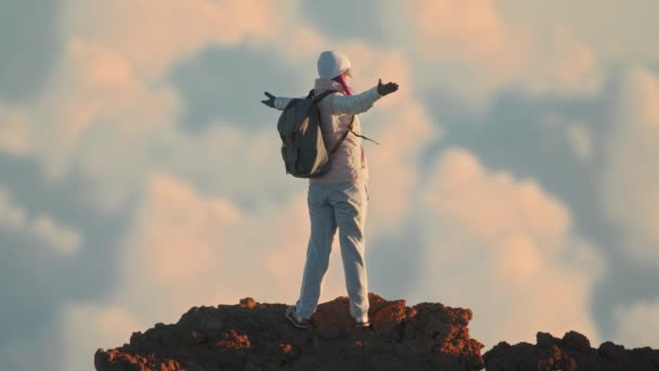 Cinématique ralenti femme victorieusement sur le sommet de la montagne coucher de soleil nuages vue — Video