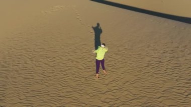 Spor giyim sektöründe kadın gün batımında sanal gerçeklik oyununda okçuluk oynuyor, 4K hava sahası.