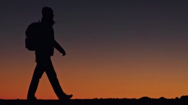 Seyahat arka planında manzaralı altın gün batımı manzarası. Gezgin silueti 4K