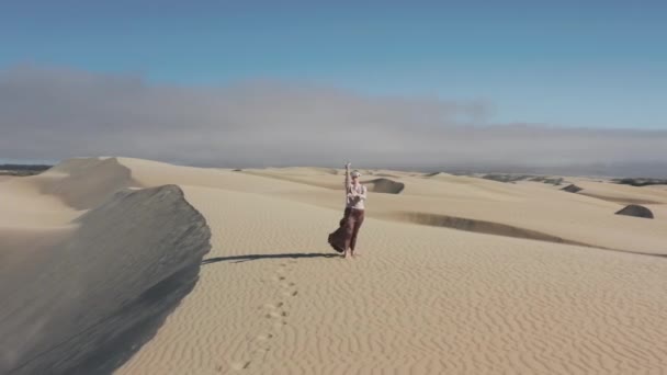 Kobieta robi ręcznie gesty tworząc malarstwo sztuki na zewnątrz w piasku pustyni 4K shot — Wideo stockowe