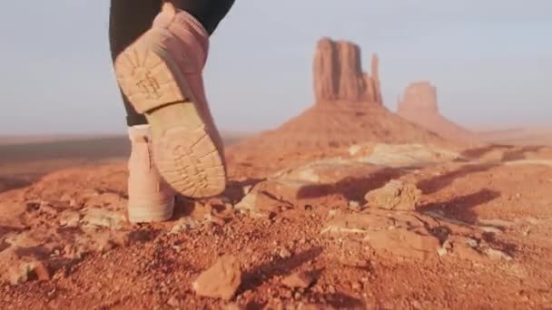 Закрыть пешие ботинки замедленным движением на фоне кинематографической дикости пустыни — стоковое видео