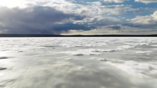 Drone volando rápido por encima del glaciar de fusión o la cubierta de hielo del lago de montaña de invierno — Vídeos de Stock