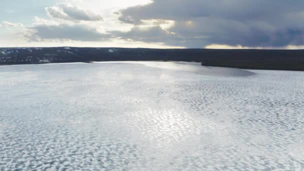 Drón repül a fagyott tó felett olvadó jég pajzs és felhők visszaverődés 4K — Stock videók