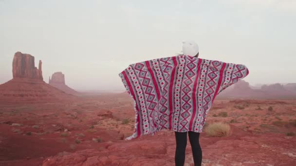 Vrouw met traditioneel patroon deken in rood west Amerikaanse woestijn bij zonsondergang 4K — Stockvideo