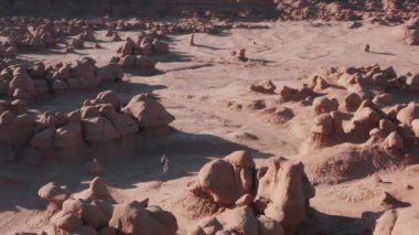 Drone, Red Rock Çölü 'nde sırt çantasıyla gezen atletik bir kadınla uçuyor.