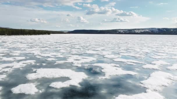 Lac de montagne avec eau bleue dans la glace fondante, reflet du ciel dans l'eau en hiver — Video