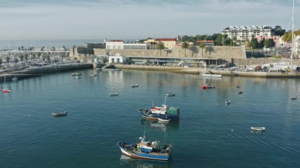 Barcos de pesca y barcos flotan en aguas abiertas con un muelle en el fondo — Vídeo de stock