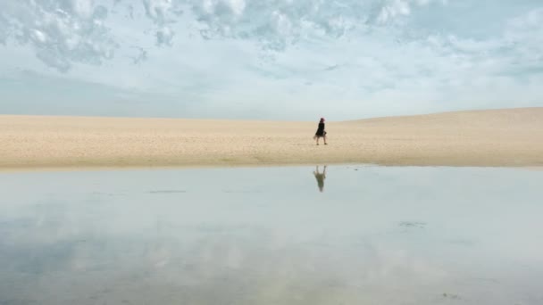 Mulher caminhando na borda da praia de areia com céu bonito no fundo — Vídeo de Stock