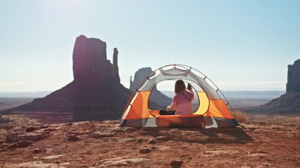 Camping kobieta w jasnym namiocie biorąc zdjęcie piękne Monument Valley, 5G połączyć — Wideo stockowe