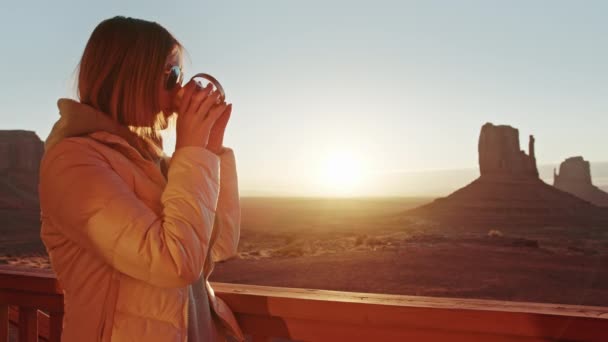 Young woman staying on cabin terrace, enjoying new day, drinking coffee sunrise — Stock Video