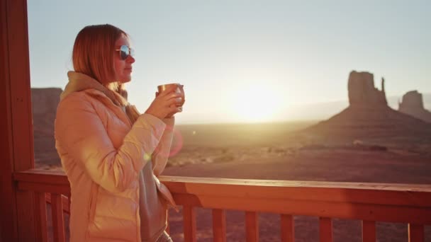 Όμορφη γυναίκα στο μπαλκόνι του ξενοδοχείου με μεγάλη φύση τοπίο πίνει ζεστό καφέ — Αρχείο Βίντεο