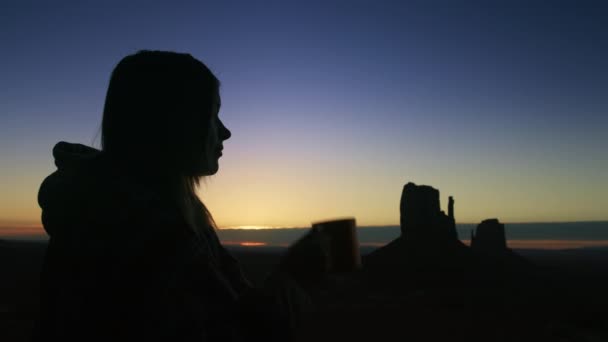 Donna dalla silhouette scura che si rilassa, beve, gode di un bellissimo tramonto o alba — Video Stock