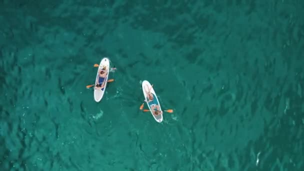 Vue aérienne du peuple sur des canots dans les eaux turquoise de la mer — Video