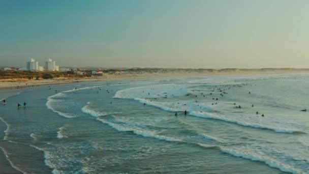 Baleal, Portugália, Európa. Drónfelvételen emberek szörföznek a parton. — Stock videók