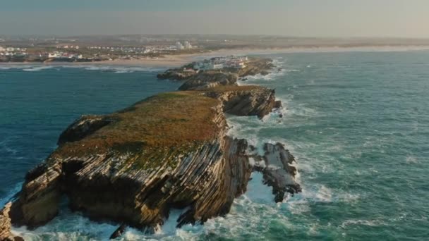 Luftaufnahme einer einzigartigen Landschaft mit felsigen Klippen, die von schäumenden Wellen überspült werden — Stockvideo