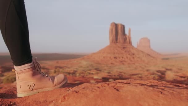 Nahaufnahme Frauenbeine in pinkfarbenen Wanderschuhen, die durch die rote Wüste im Monument Valley laufen — Stockvideo