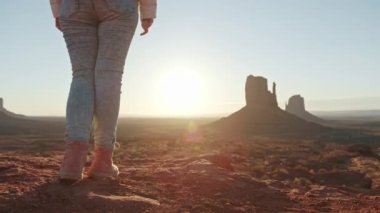Günbatımında Monument Vadisi 'nde gezgin kadının doğa geçmişi 4K.
