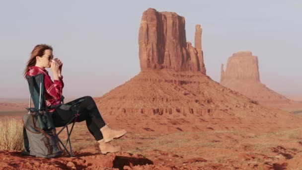 Gelukkig vrouw in camping stoel in woestijn wildernis rood montage klif achtergrond — Stockvideo