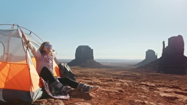 Glückliche junge Frau begrüßt neuen Tag im Monument Valley, Frau wacht langsam auf — Stockvideo