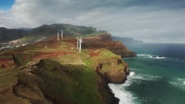 Uçurumun kenarındaki yenilenebilir rüzgar enerjisi istasyonu, okyanusla yıkanmış.