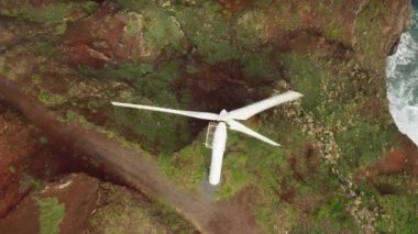 Modern rüzgar türbinlerinin havadan görünüşü arkasında deniz manzarası olan elektrik üretiyor.