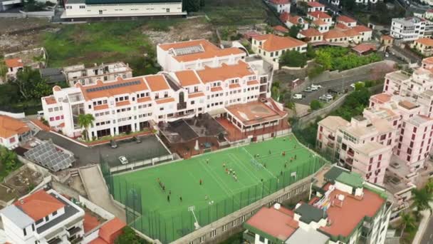 Filmagem aérea do complexo desportivo no meio da encantadora vila do vale — Vídeo de Stock