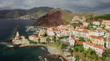 Deniz seviyesinden tepe boyunca uzanan bir yerleşim yerinin havadan görünüşü