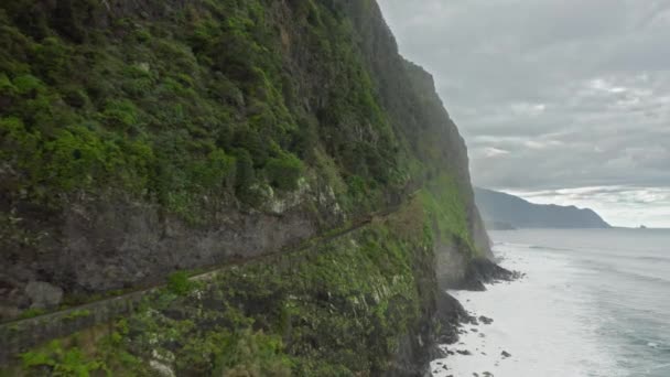 Vista aérea de acantilados escarpados con cascada escénica y exuberante vegetación — Vídeos de Stock